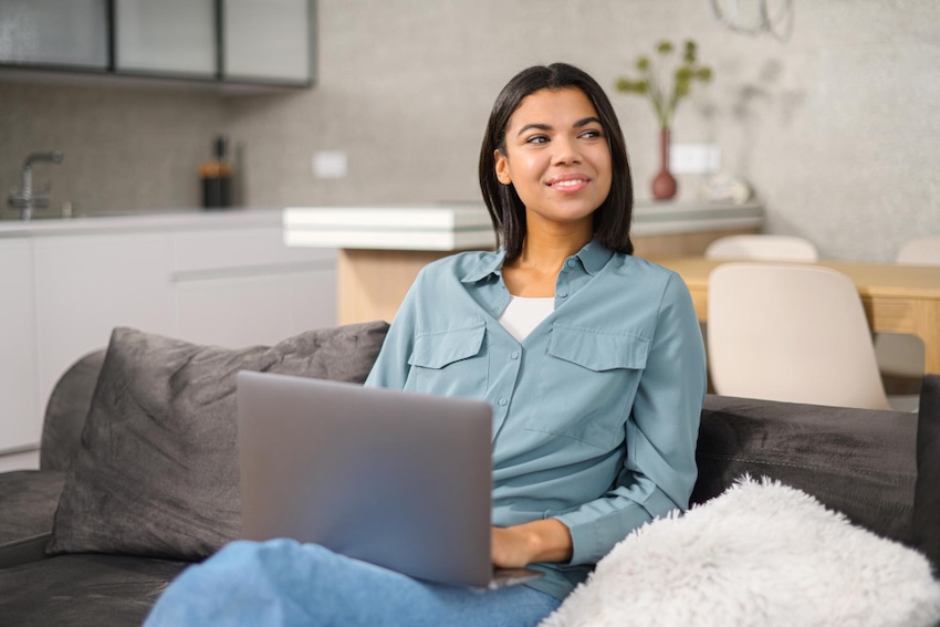 mujer sentada en el sofá con un portátil haciendo terapia online