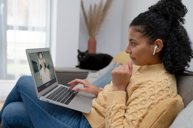 mujer en casa mirando portátil hablando con psicóloga online