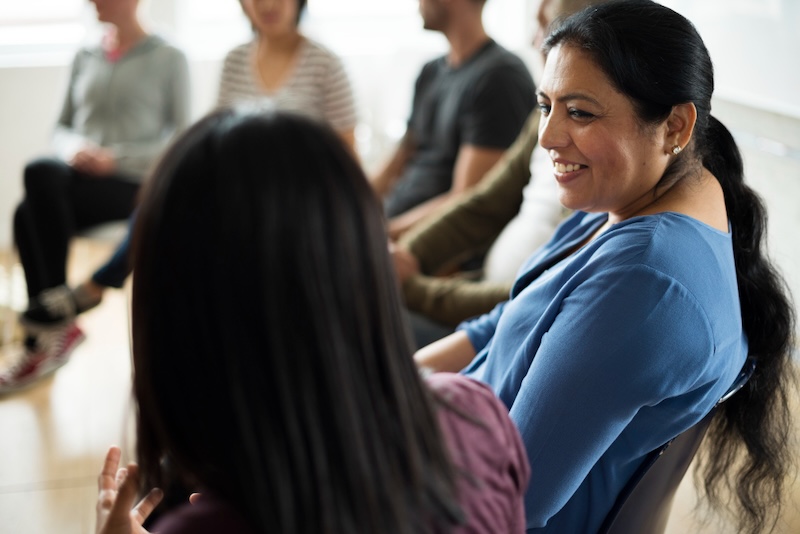 terapia grupal dos mujeres hablando sonriendo