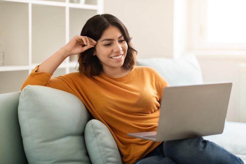 mujer sentada sofá con su laptop terapia online