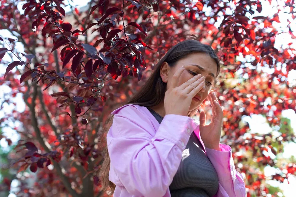 Mujer sufriendo de alergias al aire libre