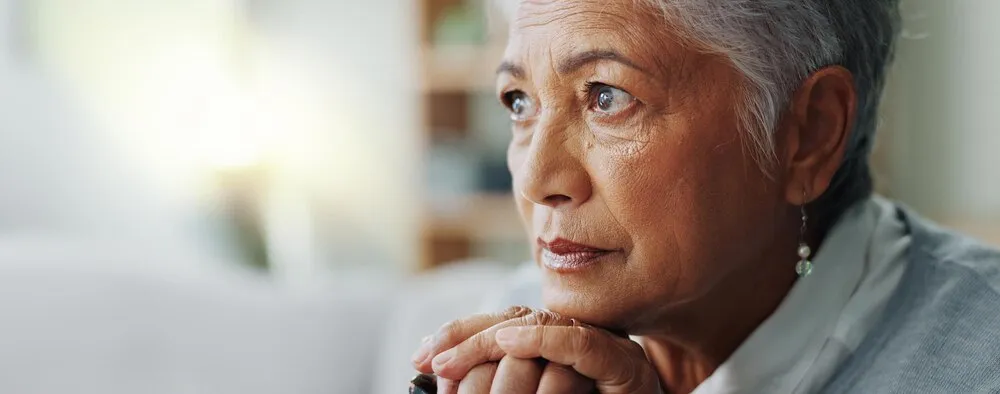 primer plano de una mujer de la tercera edad pensando con bastón para salud mental, jubilación y atención médica en una casa de reposo; persona mayor con discapacidad, bastón y triste en un sofá por artritis o demencia.