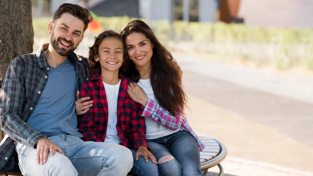 vista frontal de familia con hijo y padres al aire libre con espacio para texto