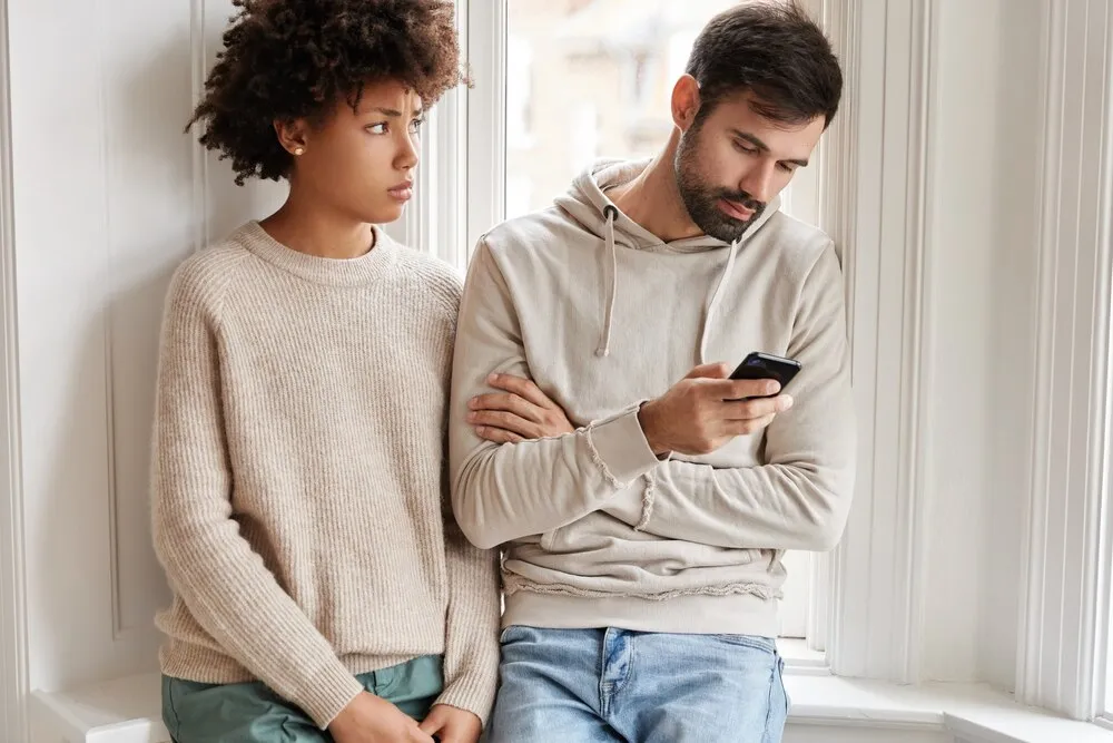 Mujer africana triste con un suéter holgado se siente disgustada al ser ignorada por su novio, necesita una comunicación animada.