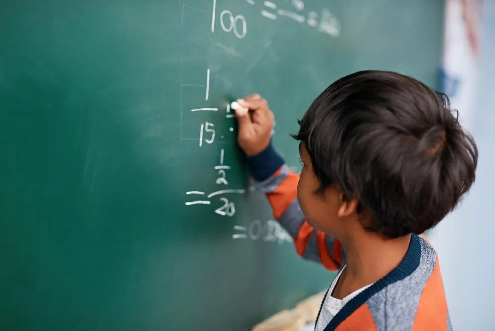 niño pequeño escribiendo y matemáticas con pizarrón para educación de ecuaciones o aprendizaje en la escuela persona masculina niño o niño pequeño con números matemáticos suma o resolución de problemas para respuesta en el salón de clases